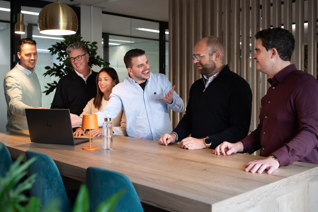 Group of talking people around a laptop