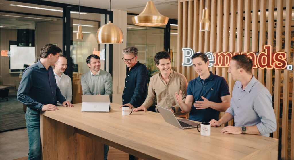 people talking to each other and looking at laptop
